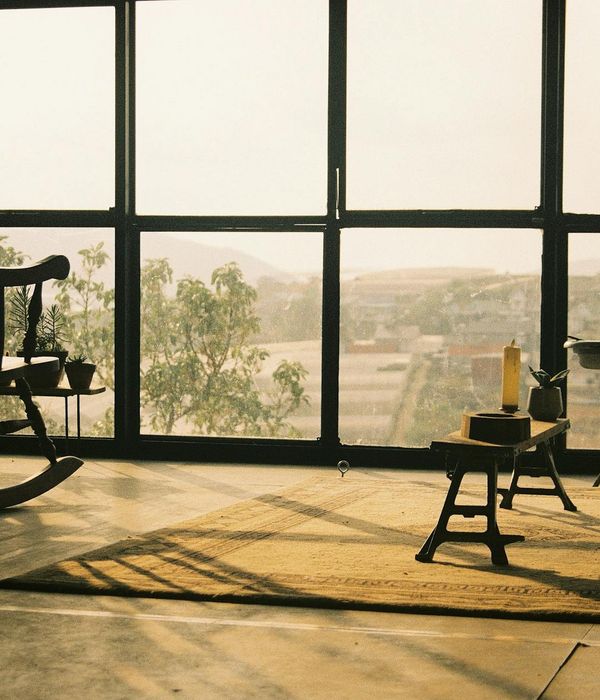 A minimalist and spacious room with a yoga mat, bathed in soft, natural light, creating a peaceful atmosphere.